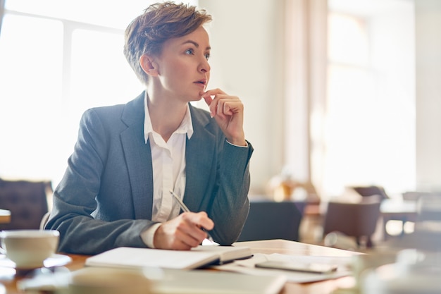 Free photo pensive businesswoman at coffeehouse