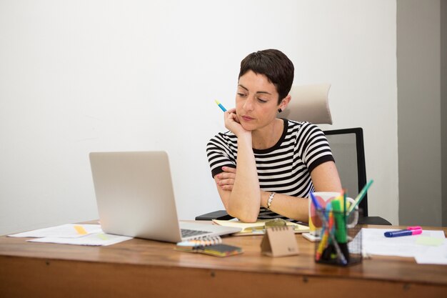 Pensive businesswoman looking at her laptop