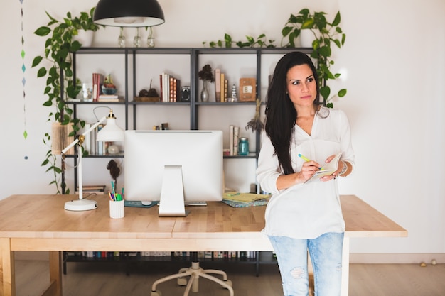 Free photo pensive employee with a notebook in hands