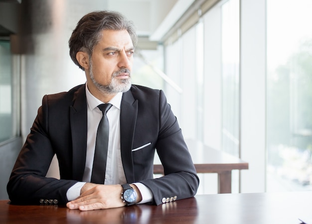 Free photo pensive entrepreneur sitting at empty desk