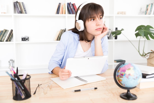 Pensive female student listening to music