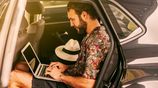 Pensive freelancer working remotely in car