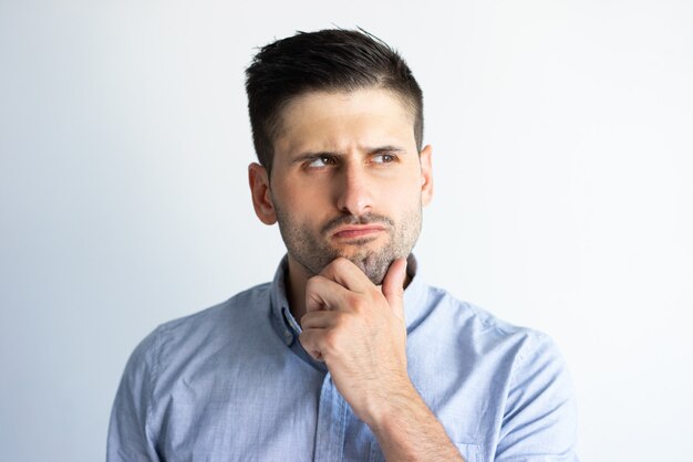 Pensive frowning guy in casual making decision