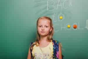 Free photo pensive girl at blackboard