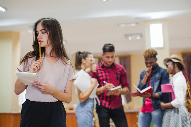 Pensive girl posing on background of students