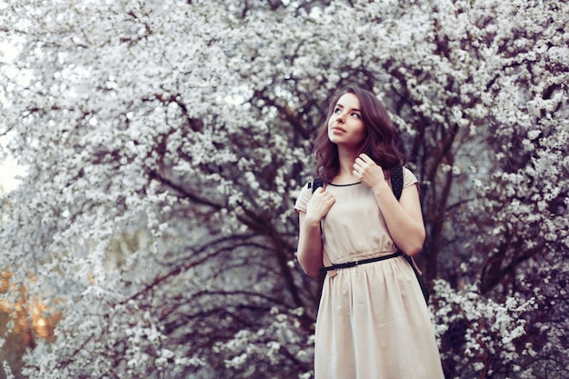 Pensive girl wearing dress with tree background