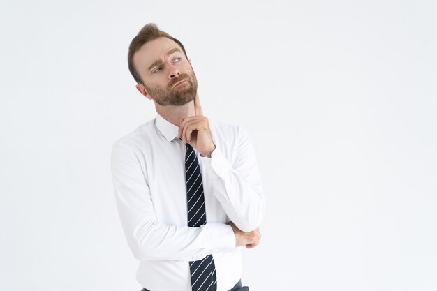 Pensive handsome young businessman looking aside