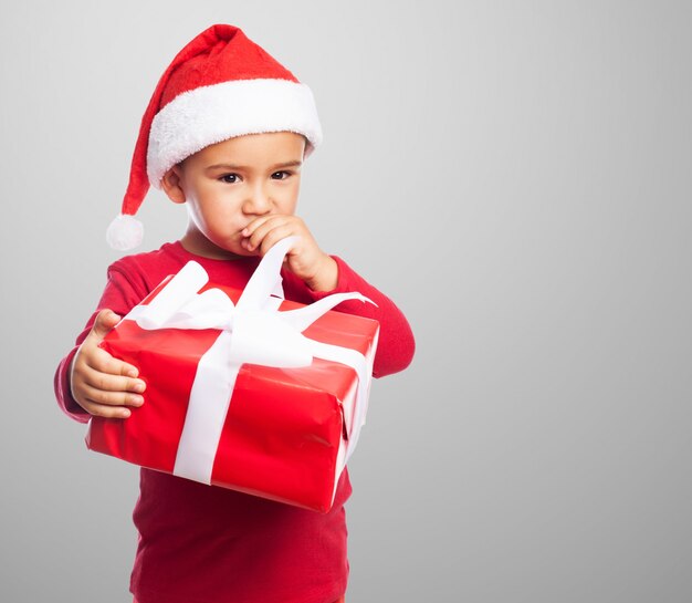 Pensive kid with one hand on the mouth