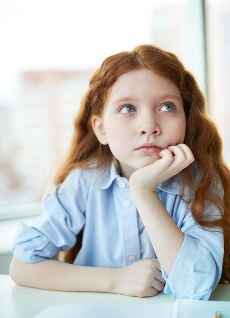 Pensive little girl in class