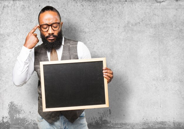 Pensive man holding a blackboard