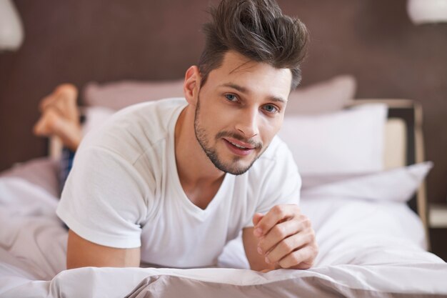 Pensive man relaxing at his cosy bedroom