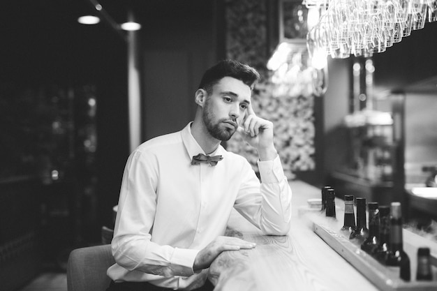 Free photo pensive man sitting at bar counter