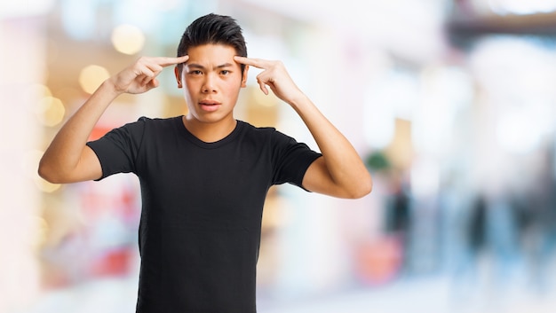 Free photo pensive man with index fingers on forehead