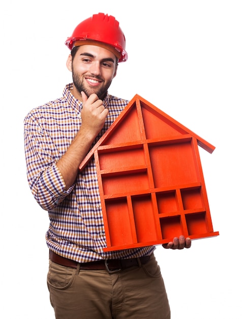 Pensive man with a red house in hands