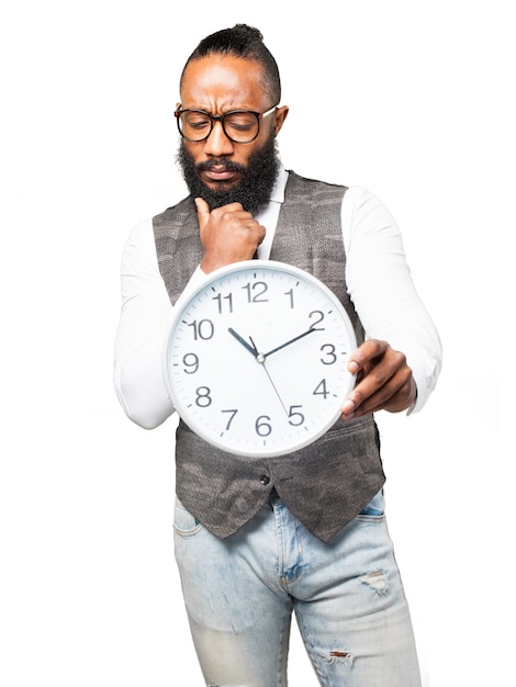 Free photo pensive man with tie looking at a clock