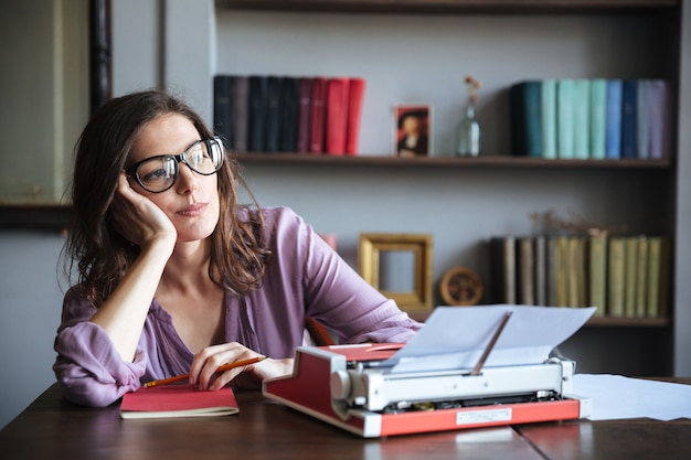 Free photo pensive mature authoress in eyeglasses thinking and looking away