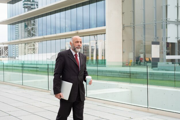 Pensive mature company owner drinking coffee