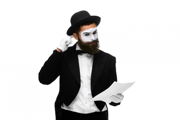 Pensive mime as a businessman reading the list of paper