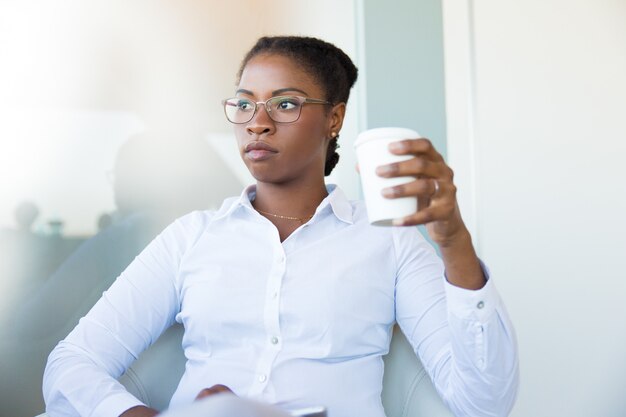 Pensive office employee enjoying coffee break