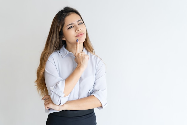 Free photo pensive pretty woman touching chin with finger and looking away