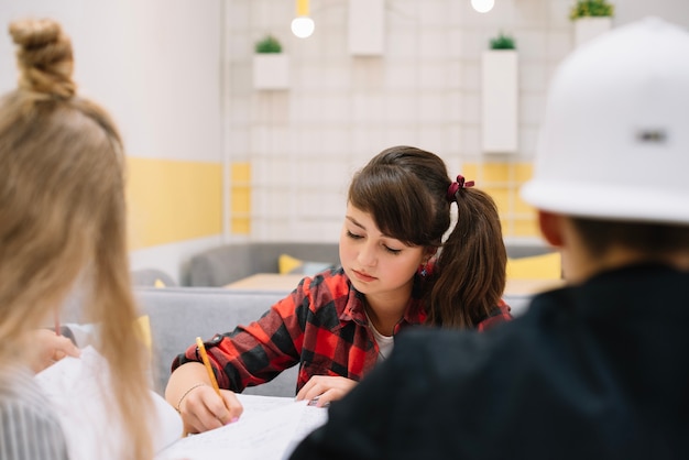 Pensive schoolgirl studying in class