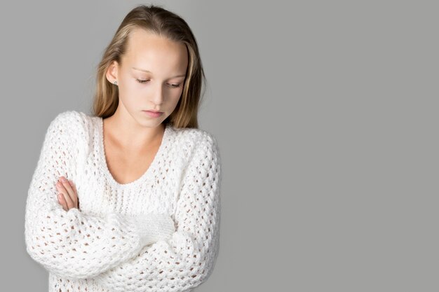 Pensive schoolgirl with crossed arms