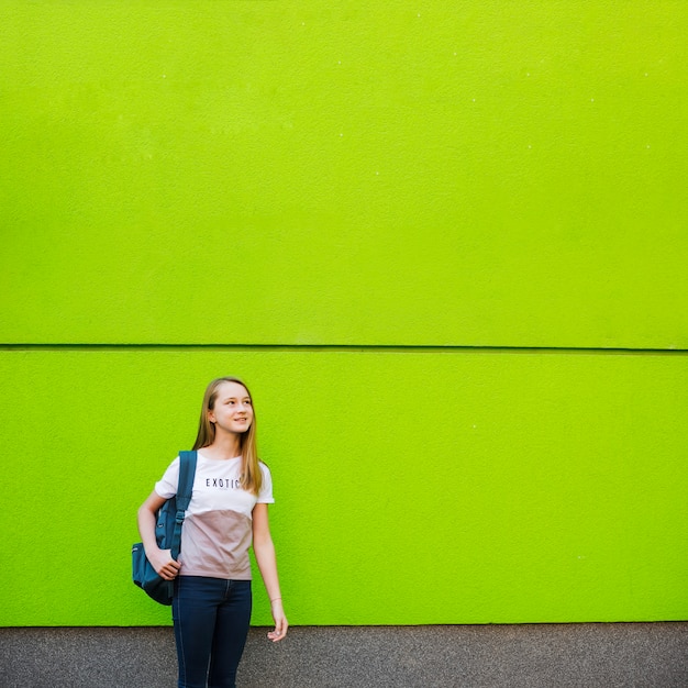 Pensive student posing on green