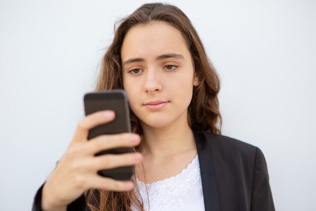 Pensive student setting new app on smartphone