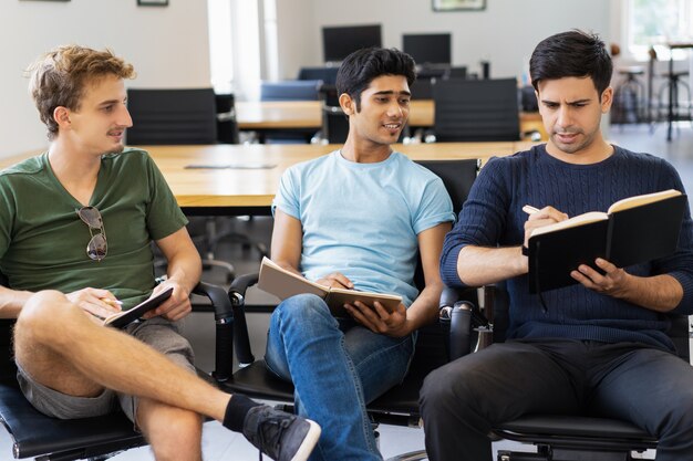 Pensive students discussing notes at class