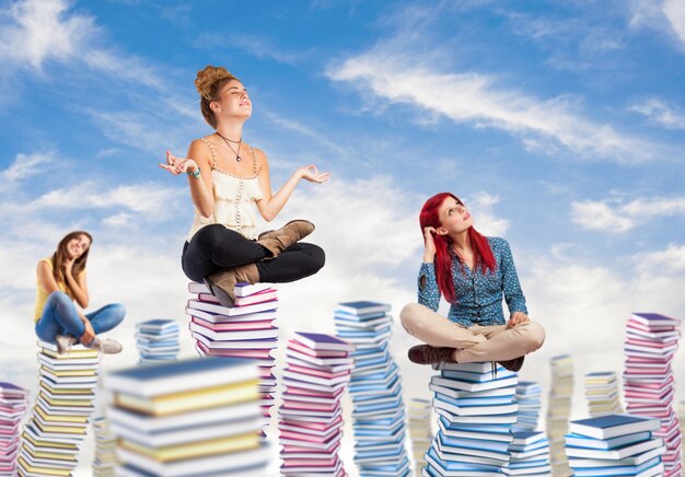 Pensive students sitting on columns of books