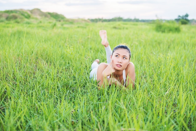 Pensive teenager lying on the grass