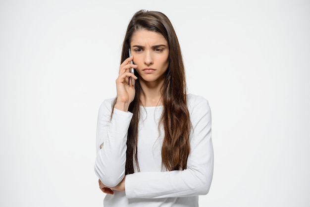 Pensive, upset woman frowning, talking on mobile phone