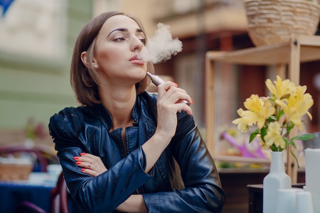 Pensive woman enjoying her electronic cigarette