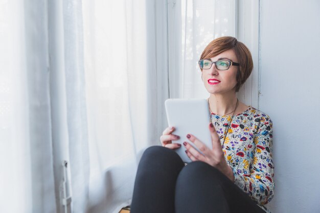 Pensieroso donna in possesso di un tablet