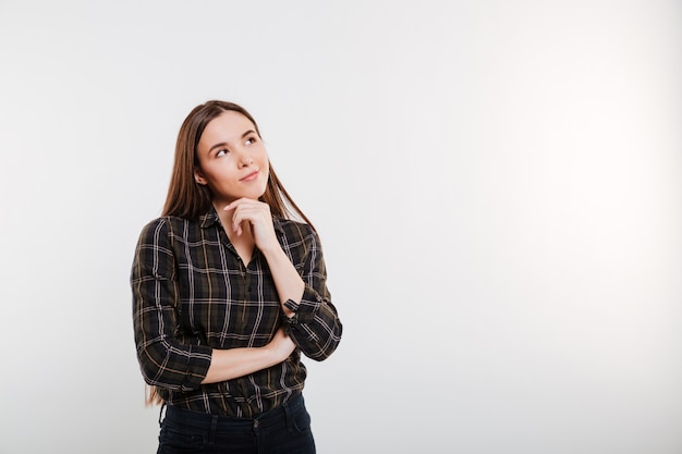 Pensive woman in shirt looking up