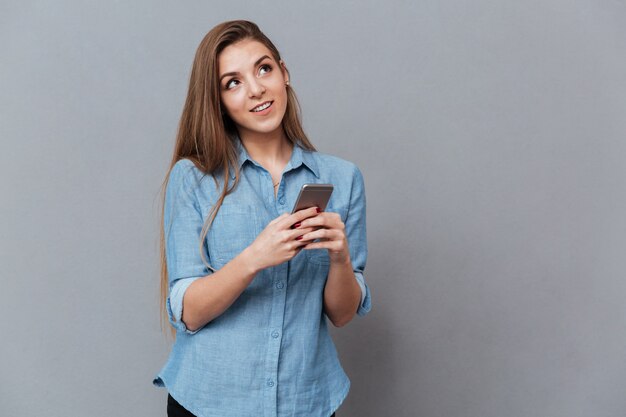 Pensive woman in shirt using phone