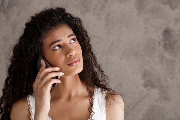 Pensive woman talking on mobile phone