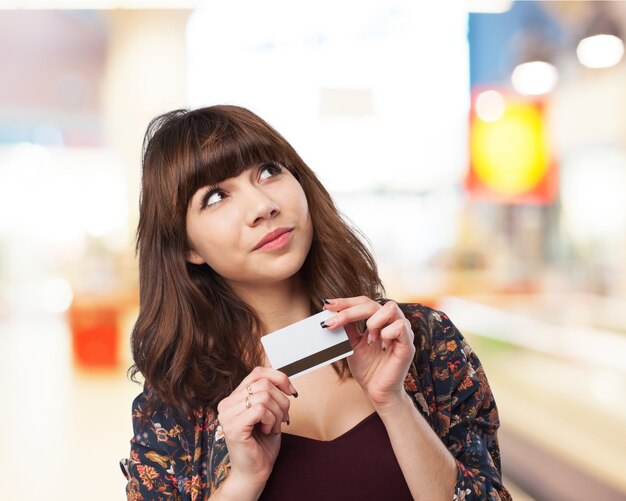 Pensive woman with a credit card