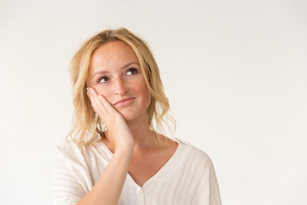 Pensive woman with hand on cheek