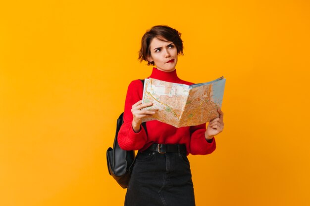 Pensive woman with map looking away