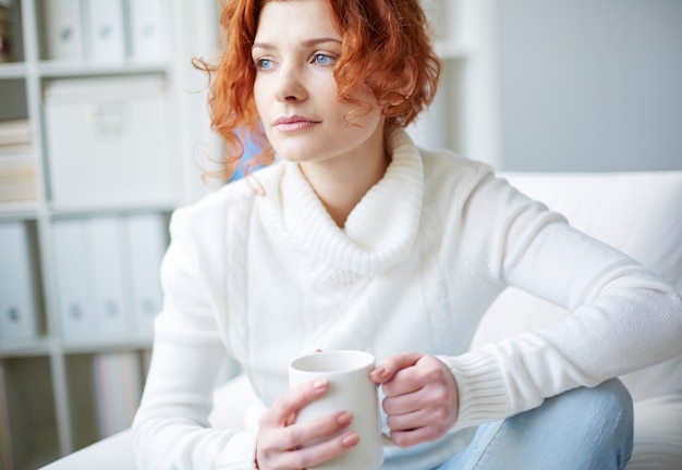 Pensive woman with a white sweater