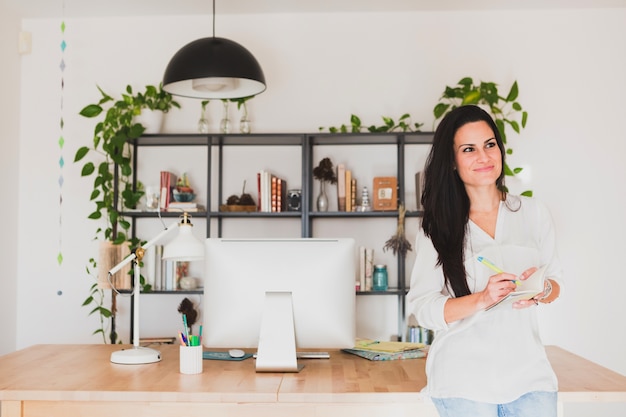 Free photo pensive woman with workspace background