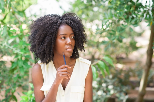 Pensive Young Black Woman Working in Park