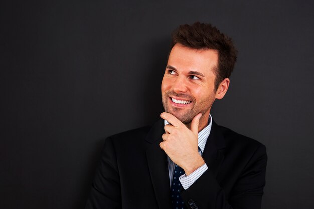 Pensive young businessman looking on side