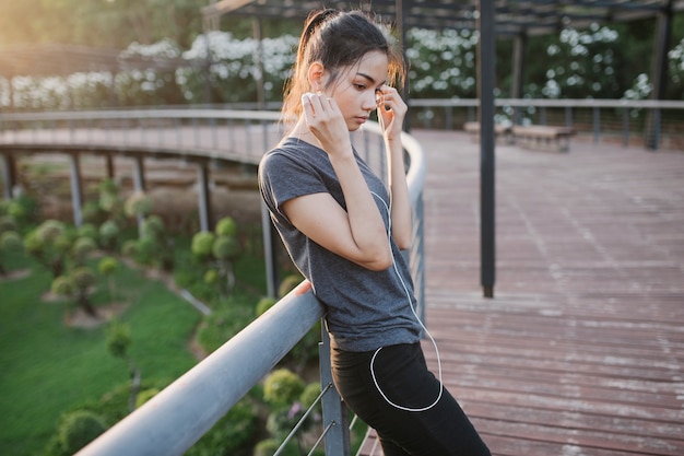 Pensive young woman listening to music outdoors