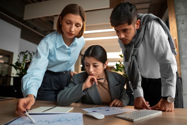 Foto gratuita persone che analizzano e controllano i grafici finanziari in ufficio