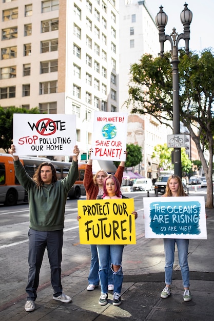 Бесплатное фото Люди во всемирный день окружающей среды протестуют на открытом воздухе с плакатами