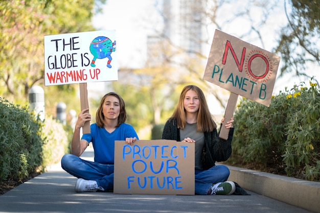 Бесплатное фото Люди во всемирный день окружающей среды протестуют с плакатами на открытом воздухе