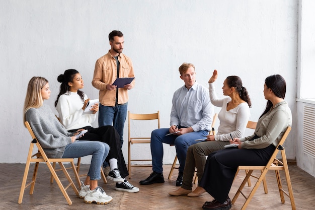 People attending a group therapy session while sitting on chairs