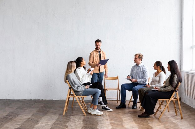 People attending a group therapy session with copy space